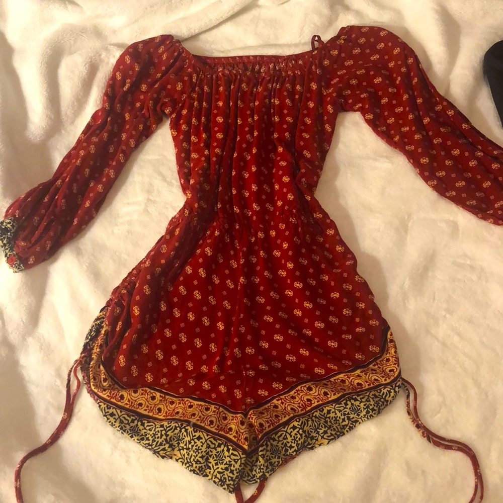 shoulderless red romper with intricate design.